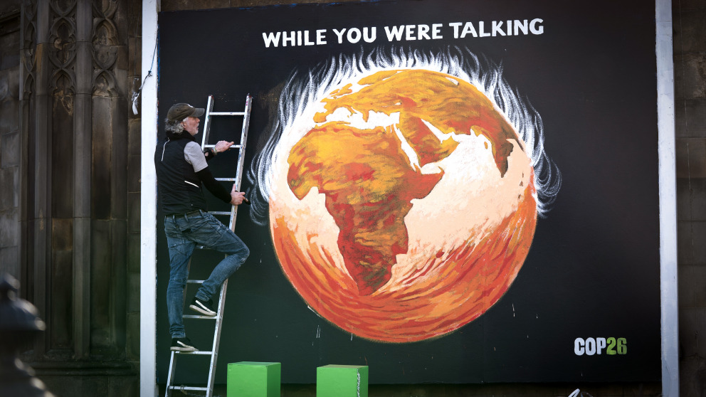 COP26 in Glasgow: artist Greg Mitchell completes his climate-crisis themed mural that depicts the Earth on fire.