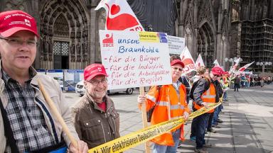 Rund 500 Demonstranten versammelten sich am 21. Mai 2015 in Köln, um gegen die Klimaabgabe auf ältere Kraftwerke Stellung zu beziehen. Mit einer Menschenkette um den Kölner Dom und der Verteilung von Braunkohle-Tütchen machten sie auf sich aufmerksam. © Markus Feger